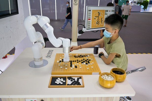 8月22日，小朋友在展場同訊飛玄機（iFlyGo）弈棋機器人下圍棋。（攝影/甘俠義）
